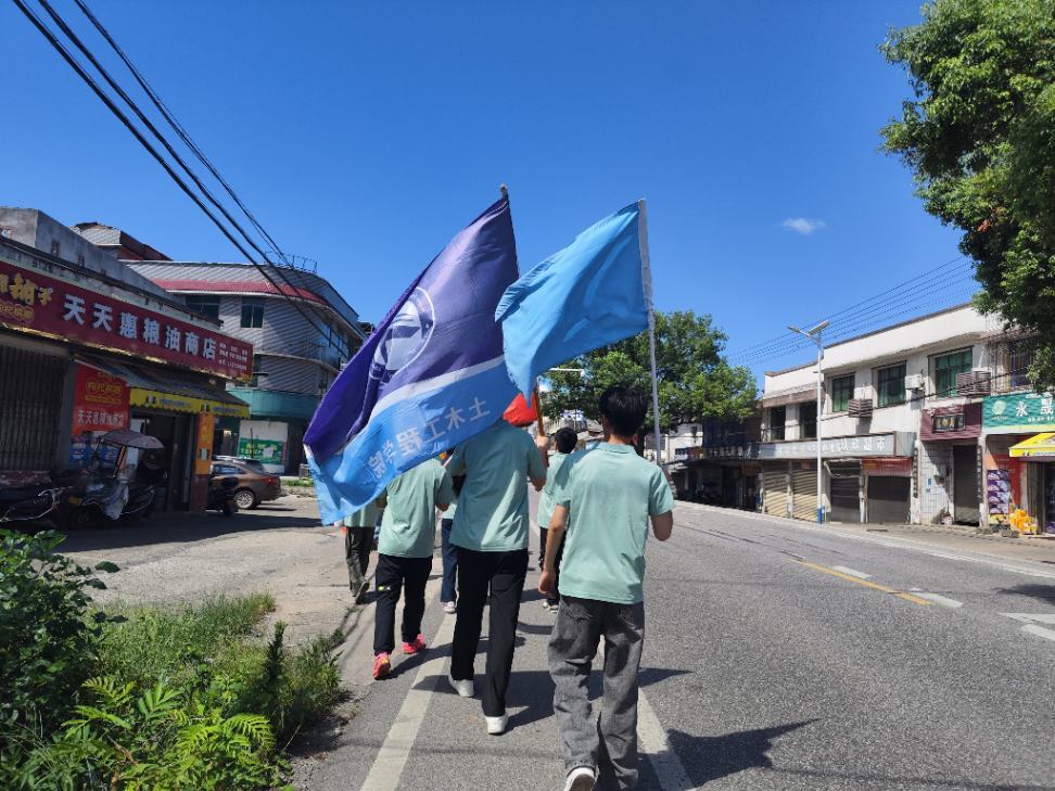 实践队员一路前行,旗帜迎风飘扬,以青春之行助力乡村教育振兴