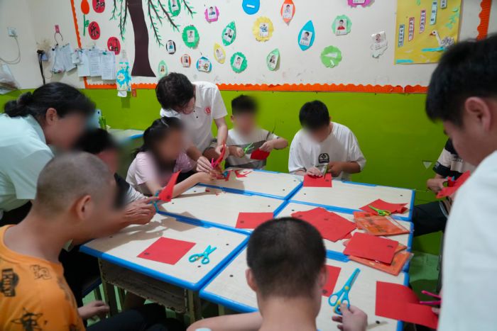 图为志愿者指导儿童体验剪纸手工。 王昊 供图