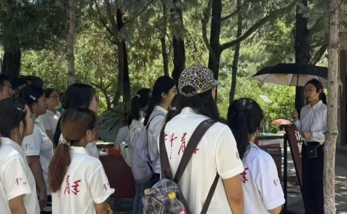 队员们认真聆听讲解员介绍宝塔山历史渊源,学习延安革命发展往事