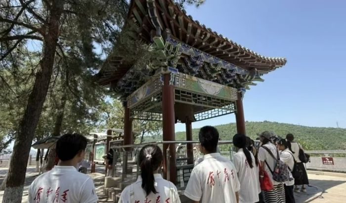 实践队员驻足钟亭,聆听古钟承载的抗战记忆,感悟烽火岁月中的军民往事