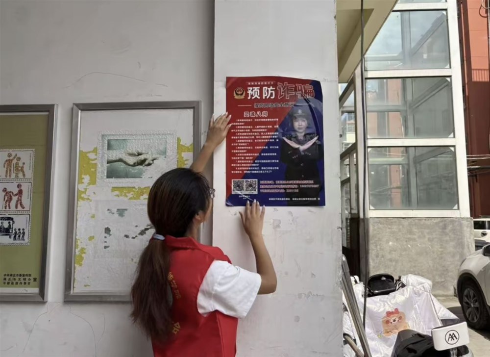 志愿者在社区张贴反诈宣传海报 燕赵暖阳志愿服务队摄