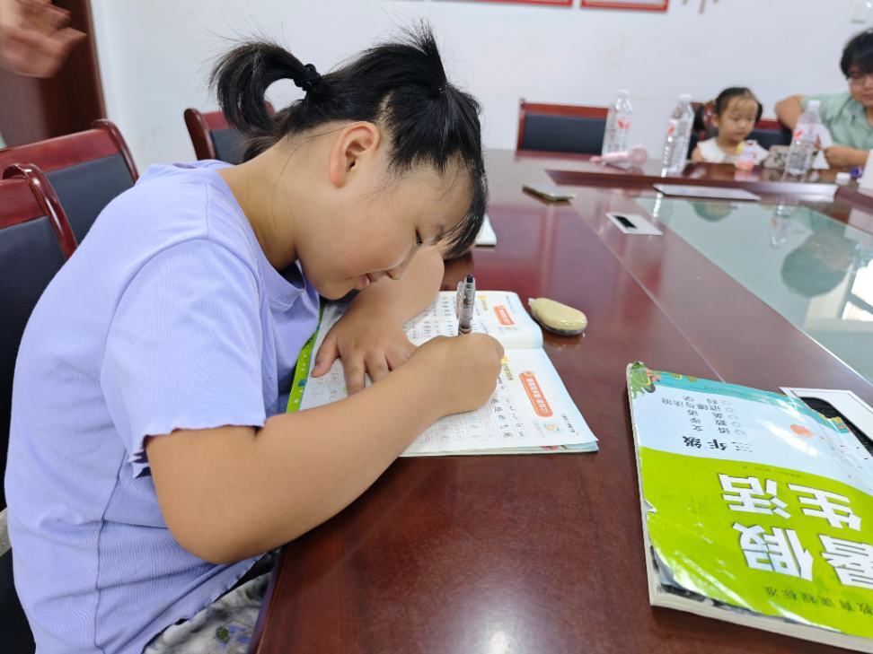学生专注伏案书写习题,认真完成暑期学习任务